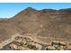 An aerial view shows many homes in a desert community against a backdrop of scenic mountains at 694 Value Ridge Ave, Henderson, NV 89012