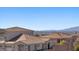 A view of a desert community, with neighborhood homes showing tiled roofs and desert landscaping at 694 Value Ridge Ave, Henderson, NV 89012