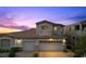 Charming home featuring a two-car garage, a Juliet balcony and a manicured front yard at twilight at 694 Value Ridge Ave, Henderson, NV 89012