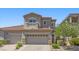 Inviting two-story home featuring a two-car garage, balcony, and well-maintained landscaping at 694 Value Ridge Ave, Henderson, NV 89012