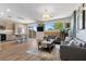 Open-concept living area with wood floors, modern kitchen, and access to outdoor space at 694 Value Ridge Ave, Henderson, NV 89012