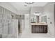 Stunning bathroom showcasing a walk-in shower with pebble floor and a vanity with dark cabinets at 6971 Moaning Cavern St, Las Vegas, NV 89131