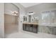 Bright bathroom featuring a vanity with dark cabinets, stone countertop, and an archway to the bedroom at 6971 Moaning Cavern St, Las Vegas, NV 89131