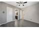 This bedroom features gray walls, wood-look tile flooring, and a ceiling fan with light at 6971 Moaning Cavern St, Las Vegas, NV 89131
