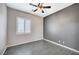 Bedroom with gray accent wall, ceiling fan, and shuttered window providing natural light at 6971 Moaning Cavern St, Las Vegas, NV 89131