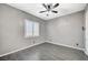 Comfortable bedroom with gray walls, tiled floors, and a ceiling fan for added comfort at 6971 Moaning Cavern St, Las Vegas, NV 89131