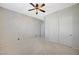 Neutral carpet and walls, a closet with sliding doors, and a ceiling fan adorn this bedroom at 6971 Moaning Cavern St, Las Vegas, NV 89131
