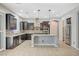 Spacious kitchen featuring dark wood cabinets, stainless steel appliances, and a large center island at 6971 Moaning Cavern St, Las Vegas, NV 89131