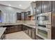 Close up view of the kitchen featuring granite countertops, stainless steel appliances and dark wood cabinets at 6971 Moaning Cavern St, Las Vegas, NV 89131