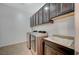 Well-equipped laundry room with dark cabinetry, a utility sink, and modern appliances at 6971 Moaning Cavern St, Las Vegas, NV 89131