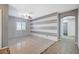 Living room with tile floors, neutral paint, decorative wall and hallway access at 6971 Moaning Cavern St, Las Vegas, NV 89131