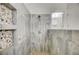 Elegant shower with a pebble floor, travertine-style tiling, and built-in shower caddies at 6971 Moaning Cavern St, Las Vegas, NV 89131