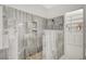 Beautiful shower with pebble flooring, travertine style tiling, and built-in shower caddies at 6971 Moaning Cavern St, Las Vegas, NV 89131