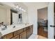 Well-lit bathroom featuring double sinks with wood cabinets and a neutral color palette at 7385 Severence Ln, Las Vegas, NV 89131