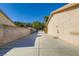 Spacious driveway extending between the home and a tall brick privacy wall at 7385 Severence Ln, Las Vegas, NV 89131