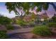 Charming home featuring desert landscaping, trees, and a tiled roof providing a welcoming exterior at 7385 Severence Ln, Las Vegas, NV 89131
