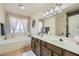 Spacious primary bathroom with dual sinks, a soaking tub, and lots of natural light at 7385 Severence Ln, Las Vegas, NV 89131