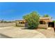 Charming single-story home featuring a gated entrance, lush landscaping and a tan exterior at 744 Mcknight St, Las Vegas, NV 89101
