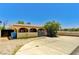 Charming single-story home featuring a gated entrance, lush landscaping and a tan exterior at 744 Mcknight St, Las Vegas, NV 89101