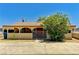 Charming single-story home featuring a gated entrance, lush landscaping and a tan exterior at 744 Mcknight St, Las Vegas, NV 89101
