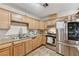 Well-lit kitchen featuring wooden cabinets, stainless steel appliances, and granite countertops at 744 Mcknight St, Las Vegas, NV 89101