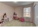Playful bedroom has pink walls, carpet, window and a closet for storage at 7705 Alder Forest St, Las Vegas, NV 89113