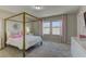 Bright bedroom features a large bed frame, plush carpet, and a view of the outside at 7705 Alder Forest St, Las Vegas, NV 89113