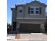 Two-story home showcasing neutral paint, a dark brown garage door, and manicured landscaping at 7705 Alder Forest St, Las Vegas, NV 89113