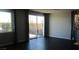 Sun-filled living room with dark hardwood floors, large windows, and modern curtains at 7705 Alder Forest St, Las Vegas, NV 89113
