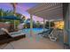 Inviting backyard oasis with a sparkling pool, lounge chairs, and a shaded pergola at twilight at 8623 Kennedy Heights Ct, Las Vegas, NV 89131