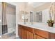 Bathroom featuring double sinks, wood cabinets, a large mirror, neutral walls, and a tub with a shower at 8623 Kennedy Heights Ct, Las Vegas, NV 89131