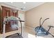 This exercise room features an armoire, treadmill, stationary bike, neutral walls, and tiled flooring at 8623 Kennedy Heights Ct, Las Vegas, NV 89131
