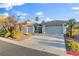 Beautiful single-story home with a three-car garage, desert landscaping, and a paved driveway at 8623 Kennedy Heights Ct, Las Vegas, NV 89131