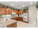 Well-lit kitchen featuring granite counters, wooden cabinetry, tile floors, and stainless steel appliances at 8623 Kennedy Heights Ct, Las Vegas, NV 89131