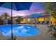 Backyard pool is surrounded by lounge chairs, umbrellas and lush landscaping for ultimate relaxation at 8623 Kennedy Heights Ct, Las Vegas, NV 89131