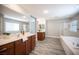 Luxurious bathroom with dual vanities, a soaking tub, glass shower, and modern fixtures at 9314 Hopcroft Ave, Las Vegas, NV 89178