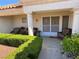 Inviting front porch with seating, lush greenery, and a decorative storm door with welcome mat at 9505 Quail Ridge Dr, Las Vegas, NV 89134