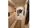 Hallway with carpet, decorative art, light wood cabinets, and an arched entryway to the dining room at 9505 Quail Ridge Dr, Las Vegas, NV 89134