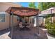 Backyard patio area with an umbrella, outdoor seating, and a storage shed for convenience at 9632 Spanish Steps Ln, Las Vegas, NV 89117