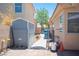 Fenced backyard featuring a storage shed, hardscape, and desert landscaping details at 9632 Spanish Steps Ln, Las Vegas, NV 89117