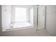 Corner soaking tub with a glass-enclosed shower, and a window for natural light at 9728 Drumcannon Ave, Las Vegas, NV 89129