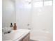 Bathroom featuring a tub with white tiles, a sink with white cabinet, and a large mirror at 9728 Drumcannon Ave, Las Vegas, NV 89129