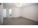 A spacious bedroom with gray carpet, white walls, and a ceiling fan at 9728 Drumcannon Ave, Las Vegas, NV 89129