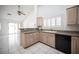Open kitchen with granite counters, white tile floor, shutters, and view into the living room at 9728 Drumcannon Ave, Las Vegas, NV 89129