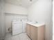 Laundry room with a washer, dryer, utility sink, and built-in shelf at 9728 Drumcannon Ave, Las Vegas, NV 89129