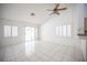 Bright living room showcasing white tiled floors, shutters, and a ceiling fan at 9728 Drumcannon Ave, Las Vegas, NV 89129