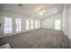 Spacious living room featuring neutral carpet, a ceiling fan, and french doors to the back at 9728 Drumcannon Ave, Las Vegas, NV 89129