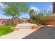 Spacious backyard featuring a concrete patio, mature trees, and manicured landscaping at 10348 Hawks Wing St, Las Vegas, NV 89178