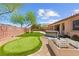 Large backyard boasts a putting green, hot tub, and desert landscaping for outdoor recreation at 10348 Hawks Wing St, Las Vegas, NV 89178