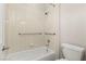 Bathroom featuring a tiled shower/tub with grab bars and a white toilet at 10348 Hawks Wing St, Las Vegas, NV 89178